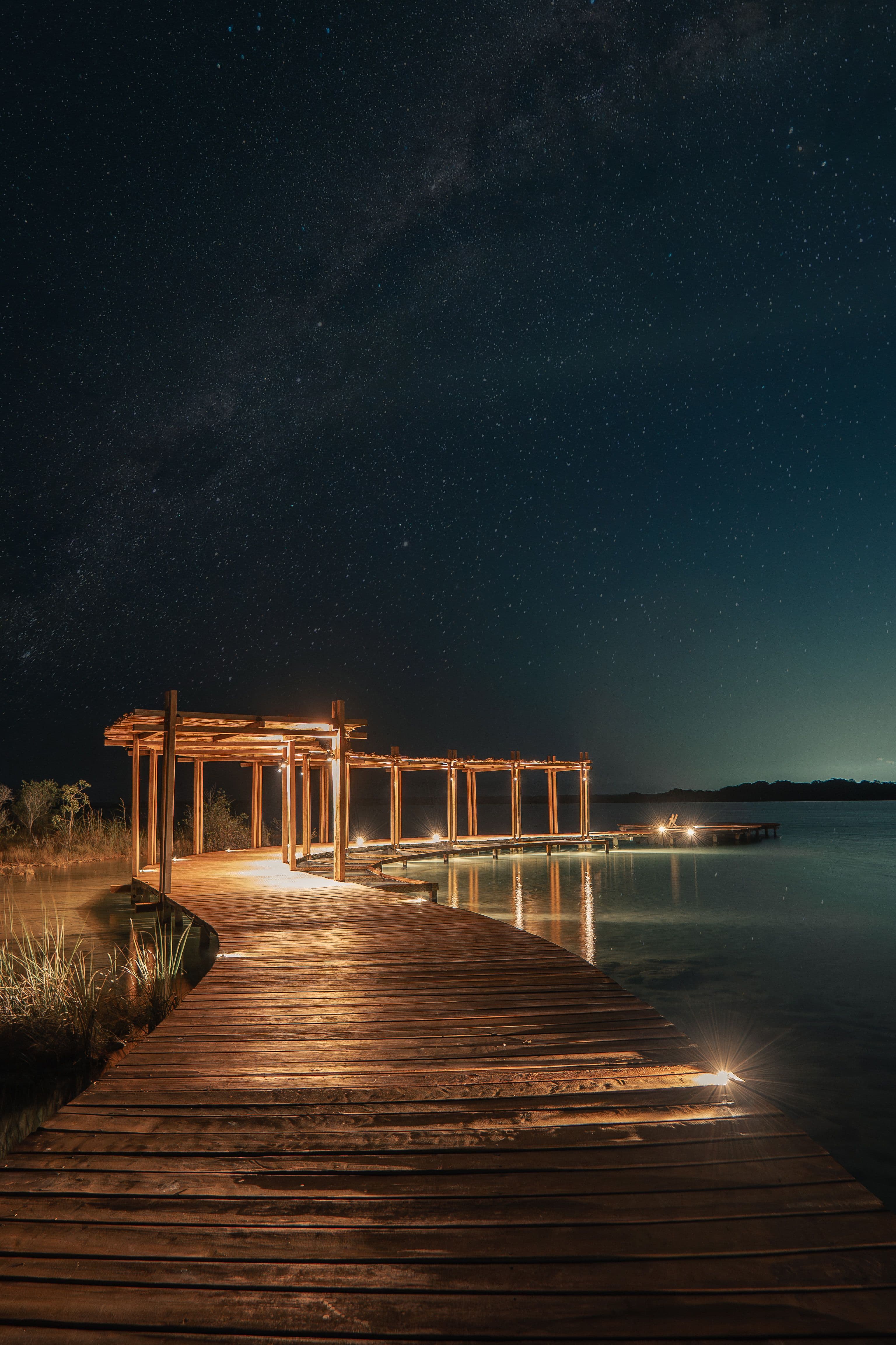 Aldea Mayab's private dock lit up at night over the lagoon