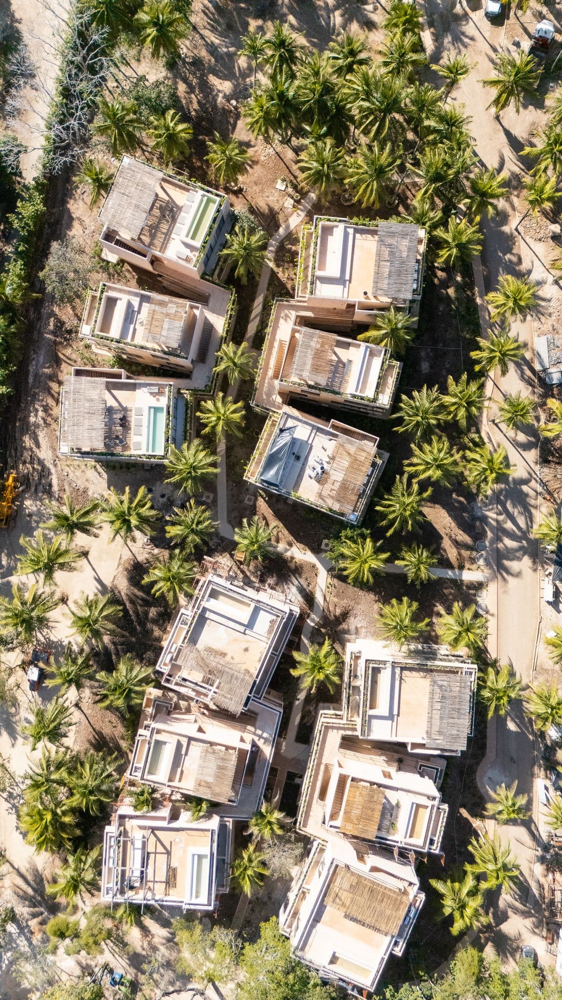 Aerial view of Aldea Mayab's residences under construction, wrapped in jungle canopy